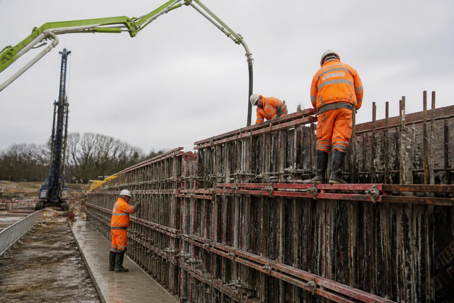 Formwork Contractors Insurance 2 Concrete pump boom placing concrete into wall formwork on a UK infrastructure project, with a formwork crew in hi-vis checking the shutters